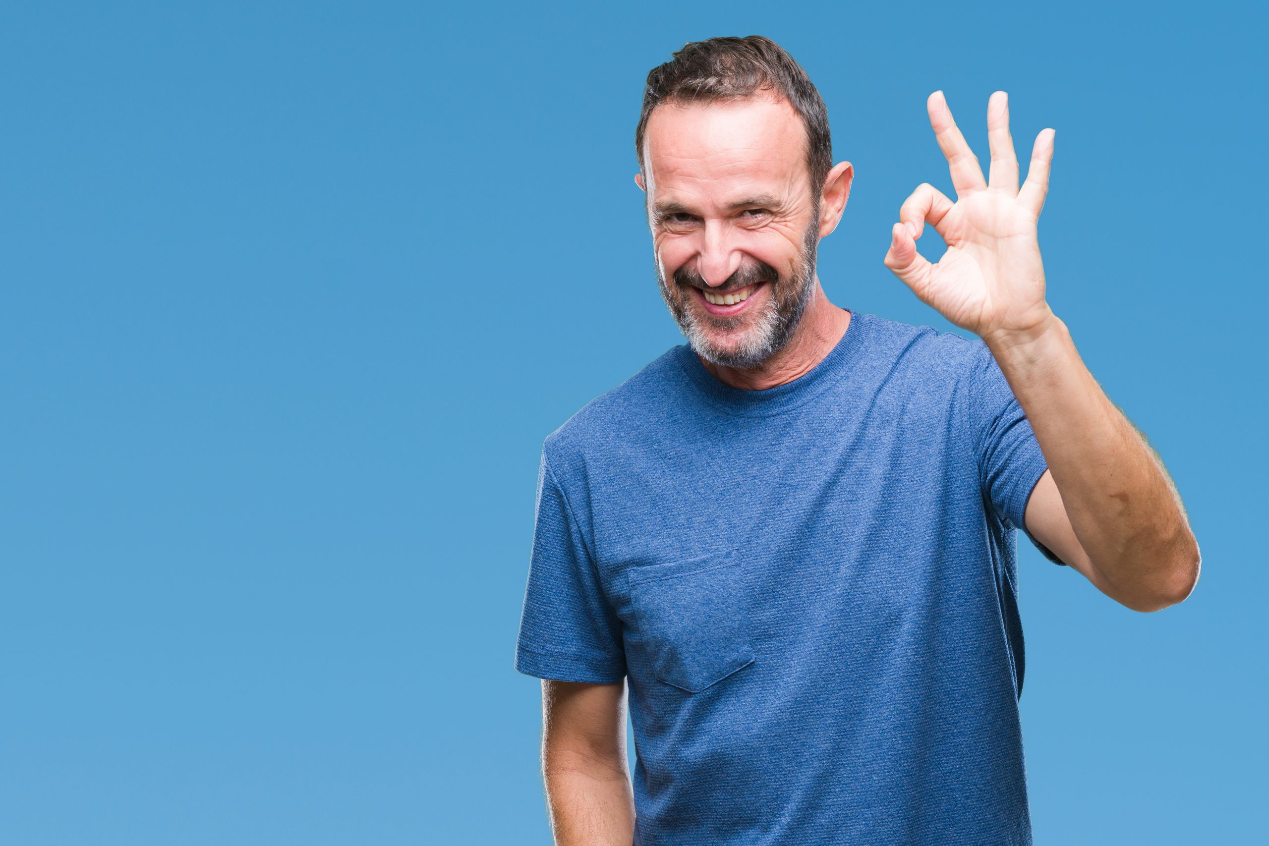 Middle age hoary senior man over isolated background smiling positive doing ok sign with hand and fingers. Successful expression.